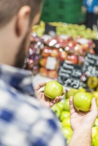 man comparing two apples, just like you should be comparing moving companies