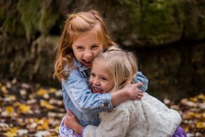 A pair of adorable, hugging girls standing in nature. Do you want your children to love the outdoors like that? Ring your movers Westchester County today.