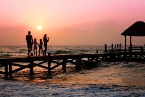 A family on a pier during sunset.